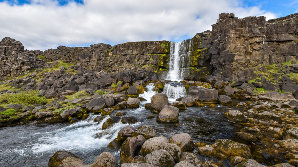 Waterfall surrounded by mossy rocks in Thingvellir National Park.